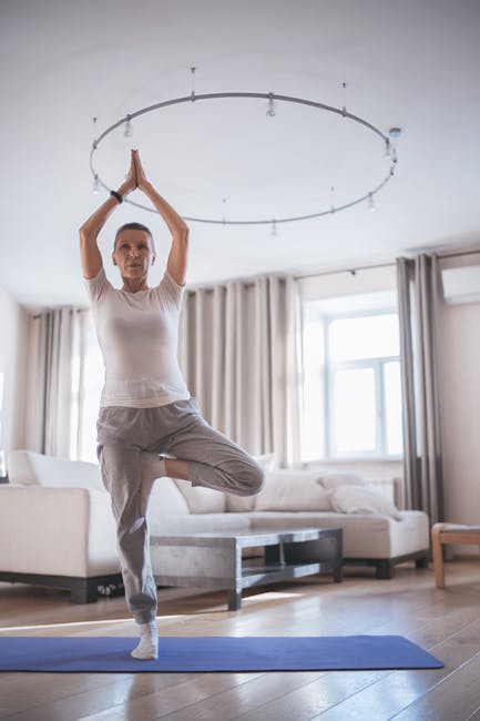 Woman relaxing in a gentle stretching pose on a yoga mat at home